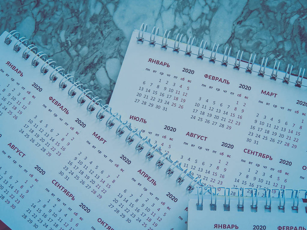 Planning a project-Close up.Thumbtack in calendar concept for busy,work space.Business meeting schedule, travel planning or project work and reminder concept.Desk calendar with days and dates.Top view - Photo, Image