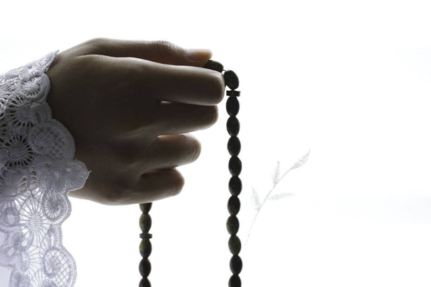 az ima gyöngyöket tartó személy részleges nézete, az iszlám vallás és a rózsafüzér gyöngyök - Fotó, kép