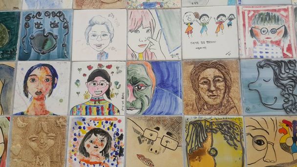 Paintings and sculpted faces of people on the wall for memoir. - Photo, Image