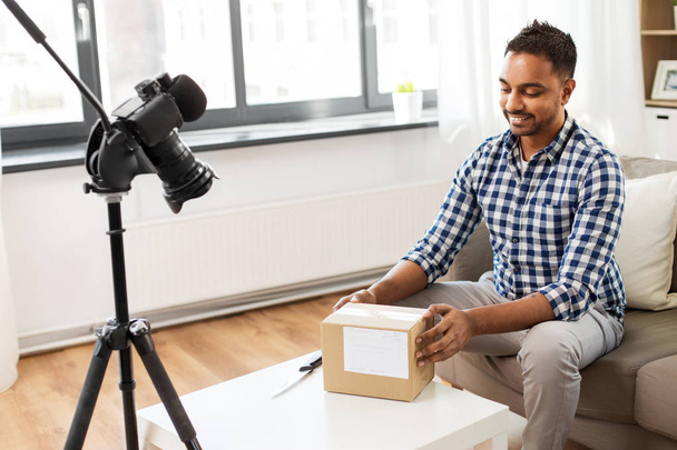 male video blogger opening parcel box at home - Foto, afbeelding