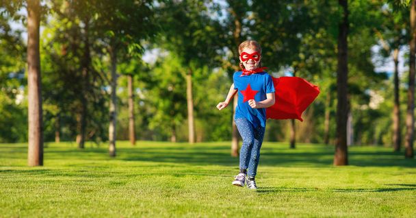 concept happy child superhero hero in red cloak  in natur - 写真・画像