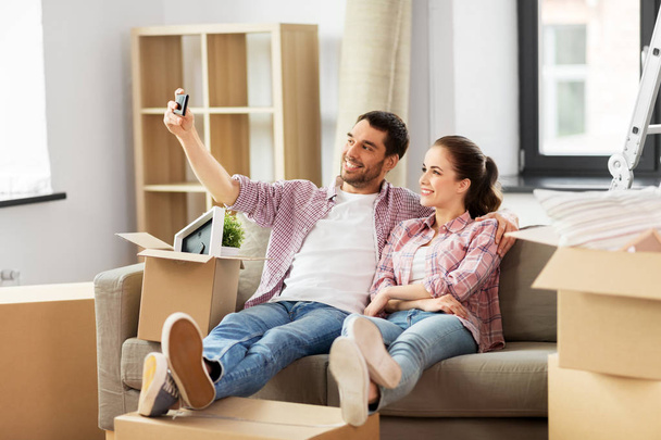 couple taking selfie by smartphone at new home - Fotoğraf, Görsel