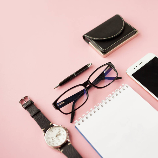 Stationery, white smartphone, glasses, pen, wallet, watch, calendar, notebook. Pink background. - Foto, immagini
