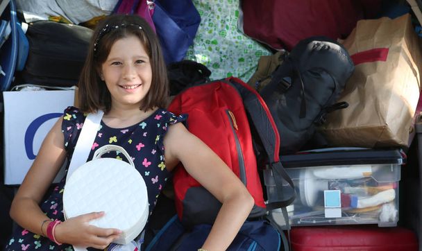 bambina e la sua macchina piena di bagagge
 - Foto, immagini