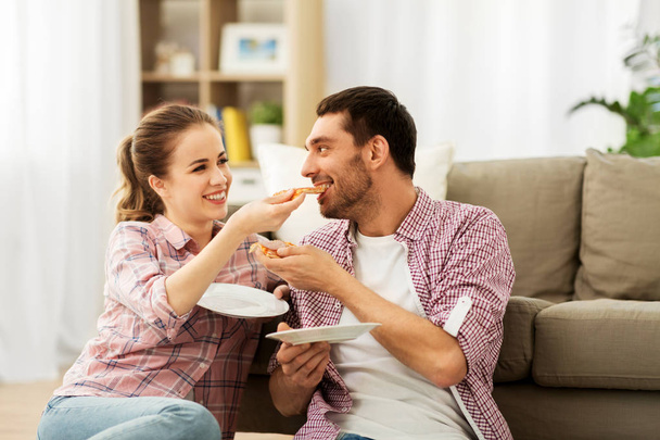 happy couple eating pizza at home - Foto, Imagem