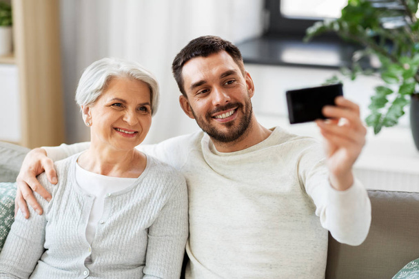senior mother with adult son taking selfie at home - Photo, Image