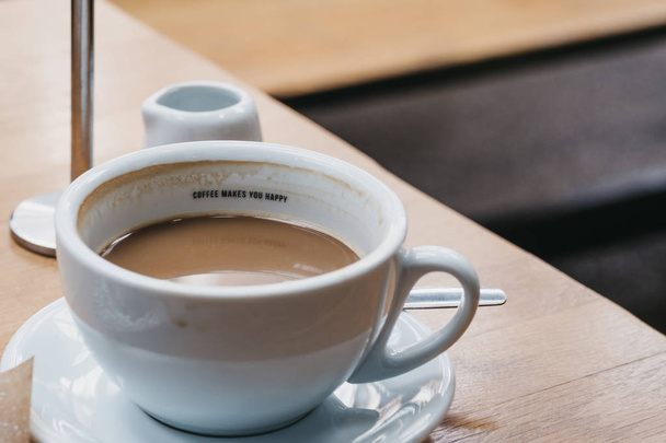 Kopje koffie met een bericht "koffie maakt je gelukkig" binnen. - Foto, afbeelding