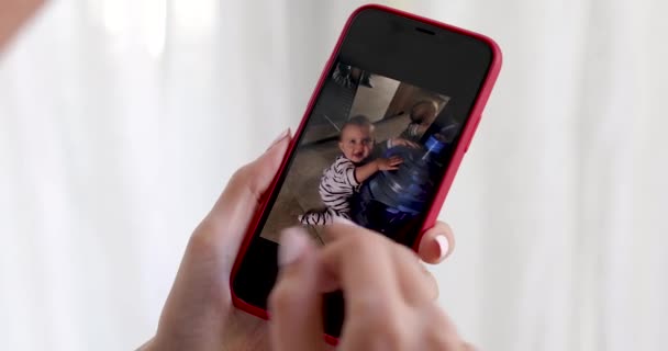 Mano de mujer con smartphone mostrando foto de niño
 - Metraje, vídeo