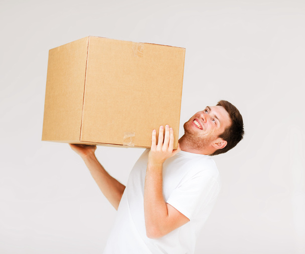 Man carrying carton heavy box - Фото, изображение
