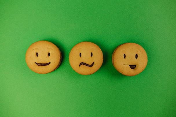 tasty cookies smiles on green background. - Photo, Image