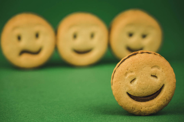 Lächelnde Kekse und andere Emotionen auf grünem Hintergrund - Foto, Bild