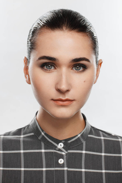 Portrait of a girl in a gray plaid shirt and with collected hair - Photo, image