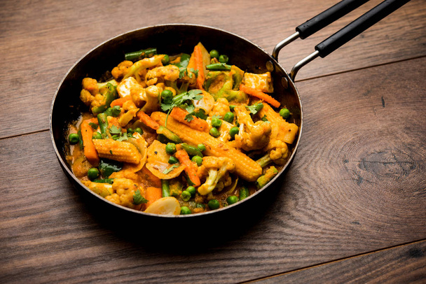Mix warzyw curry-indyjski przepis danie główne zawiera marchew, kalafior, zielony groszek i fasola, kukurydza, Capsicum i Paneer/twarożek z tradycyjnym Masala i curry, selektywne skupienie - Zdjęcie, obraz