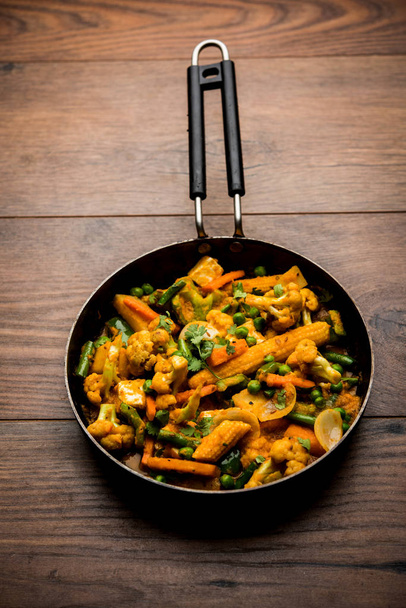 Μείγμα λαχανικών Κάρυ-Ινδική συνταγή κυρίως πιάτο περιέχει καρότα, κουνουπίδι, πράσινα μπιζέλια και φασόλια, μωρό καλαμπόκι, Capsicum και paneer/τυρί cottage με παραδοσιακό Μασάλα και κάρυ, επιλεκτική εστίαση - Φωτογραφία, εικόνα