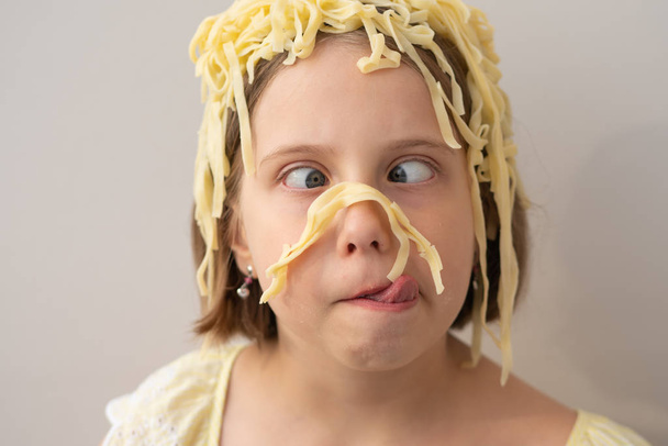 Porter een klein meisje pasta op het hoofd - Foto, afbeelding