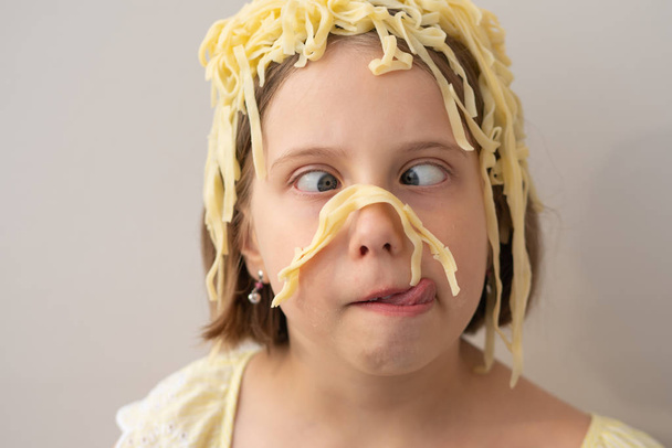 Porter een klein meisje pasta op het hoofd - Foto, afbeelding