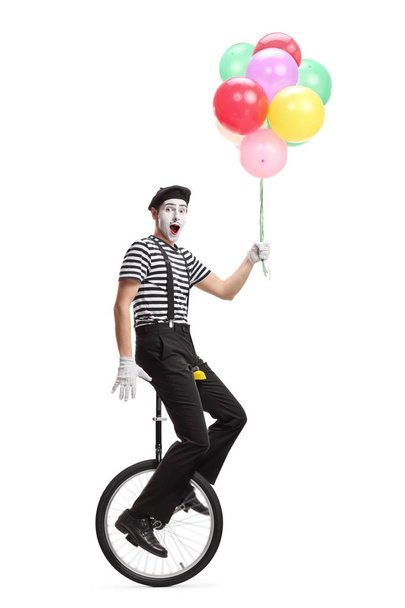 Pantomime man on a unicycle holding a bunch of colorful balloons - Φωτογραφία, εικόνα