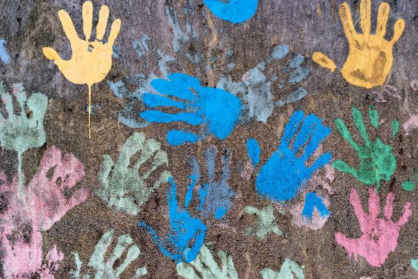 Dark background with colorful handprints symbolising interracial friendship - Photo, Image