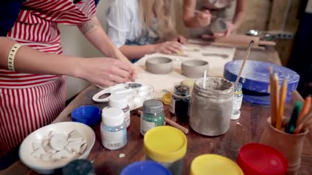 Skupina žen pracuje v keramických dílcích, dělá hliněné šálky a nátěr - Záběry, video