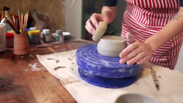 Kadın heykeltıraş çömlek stüdyosunda kil bardak yapıyor, yakın çekim görünümü - Video, Çekim