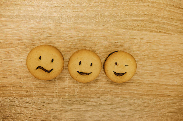galletas sonrientes y diferentes emociones sobre un fondo de madera
. - Foto, Imagen