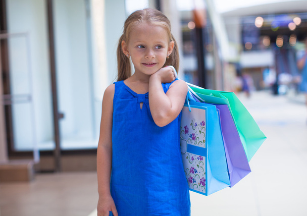 ショッピング モールで買い物袋を保持している愛らしい少女の肖像画 - 写真・画像
