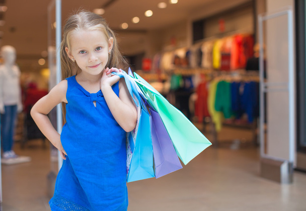 Petite fille de mode avec des paquets dans un grand centre commercial
 - Photo, image