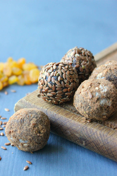 Homemade healthy raw vegan sweet balls with nuts,raisins, dates, cocoa and flax seeds. Healthy vegan food concept. Gray background. - Φωτογραφία, εικόνα