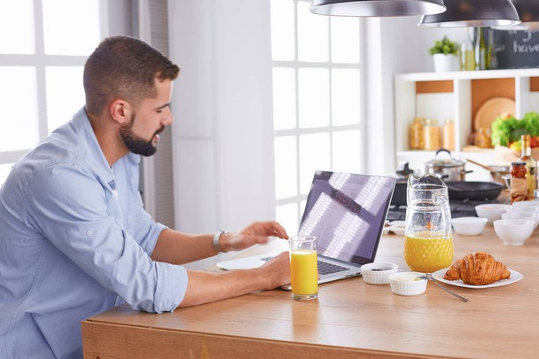 un hombre de negocios desayunos con portátil y jugo
 - Foto, imagen