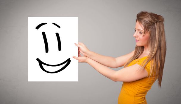 Young woman holding smiley face drawing - Photo, Image