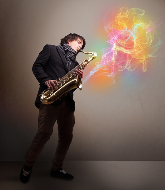 Attractive musician playing on saxophone with colorful abstract - Фото, зображення