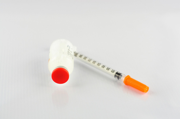 spuit en insuline flacon op witte achtergrond - Foto, afbeelding