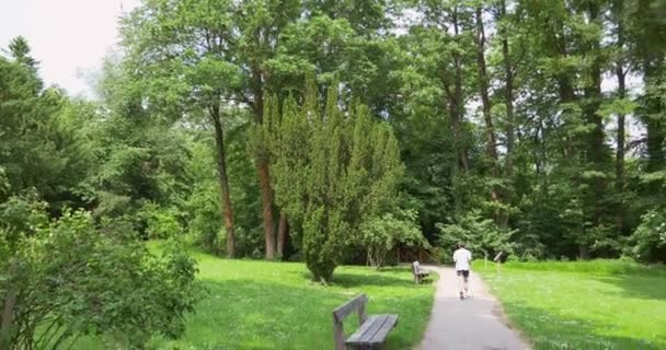 Young man running at path in green park - Footage, Video