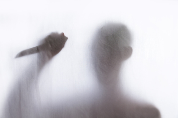 stín muže stojící za tenké látky a drží nůž - Fotografie, Obrázek