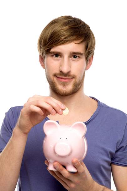 Man putting coin in piggy bank - Фото, зображення