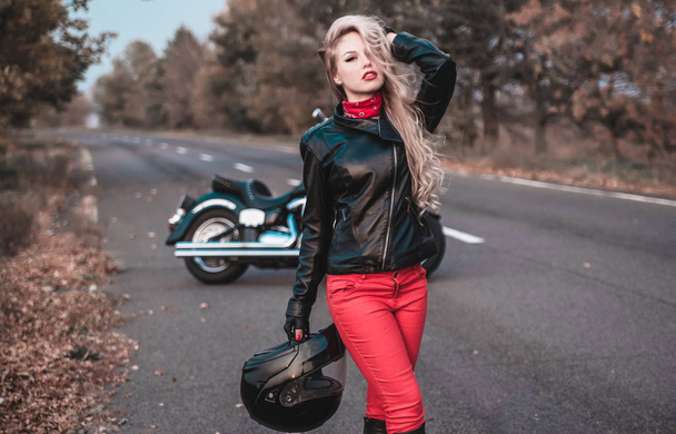 Stylish biker woman with motorcycle on the road. - Valokuva, kuva