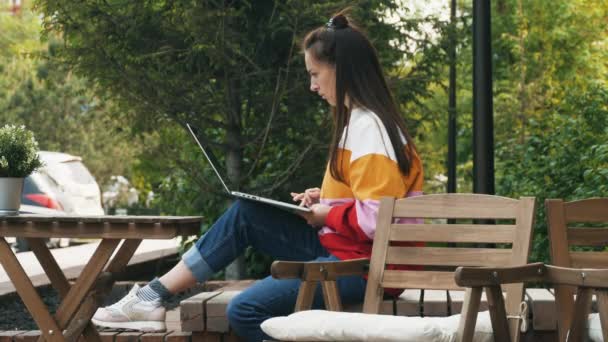 junge Frau benutzt Laptop im Freien - Filmmaterial, Video