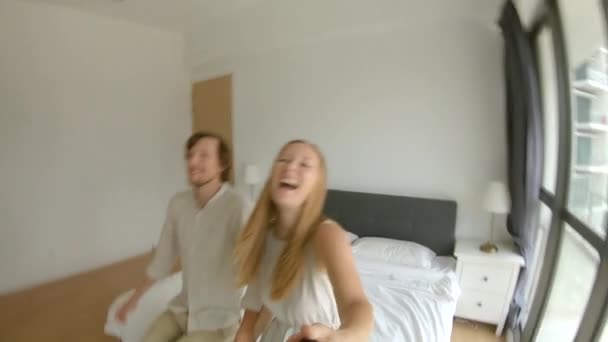 Slowmotion shot of a happy couple man and woman fall on a bed. Travel concept. Honeymoon concept - Πλάνα, βίντεο