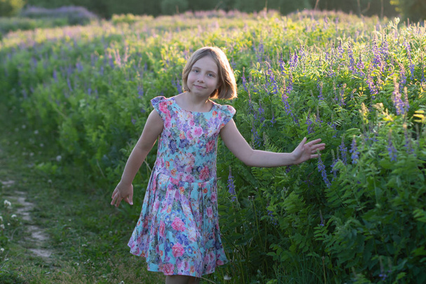retrato de una niña en el verano en el campo, de pie en un vestido de color
 - Foto, Imagen