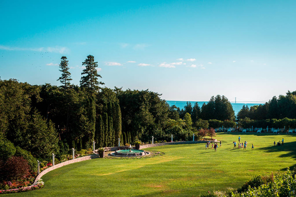 Aufnahme der Gärten des Grand Hotels an einem sonnigen Tag mit der Makrelenbrücke im Hintergrund - Foto, Bild
