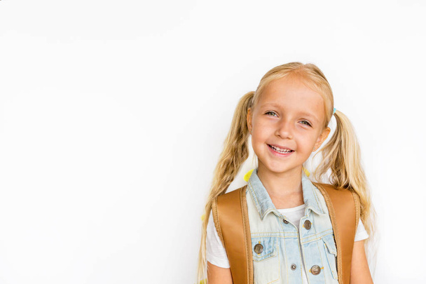 Back to school and happy time. Cute child with blonde hair on white background. Kid with backpack. Girl ready to study. Mockup, place for text, education concept - Foto, Bild