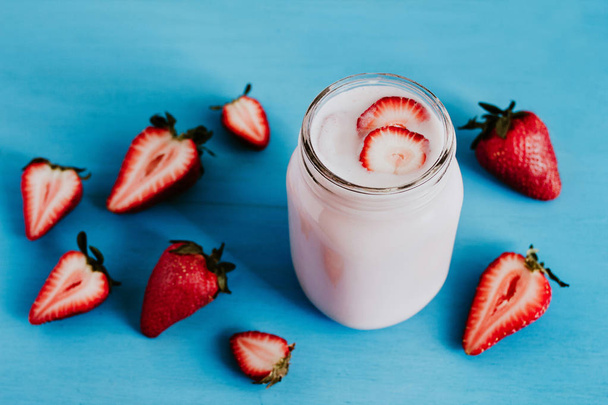Strawberry milkshake in the glass jar blue vintage background - Foto, imagen