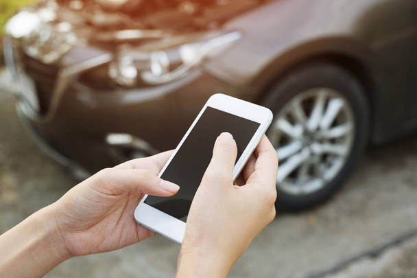 close-up zakenman hand met behulp van een mobiele smartphone bellen een auto monteur vragen om hulp, omdat auto kapot berm. - Foto, afbeelding