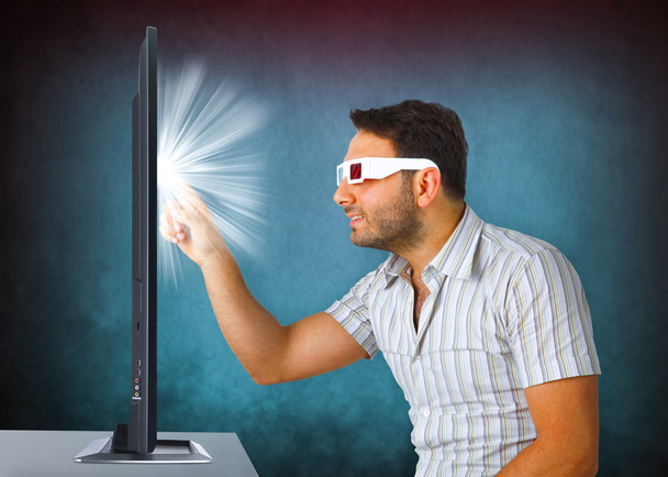 Homem vestindo óculos 3d toca a tv
 - Foto, Imagem