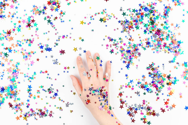 Woman hand with festive color star confetti - Фото, изображение