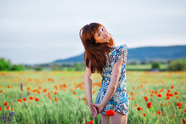 Smiling girl in poppy field - Fotoğraf, Görsel
