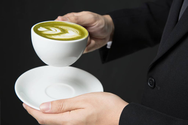 Fechar os homens usam um terno, segurando uma xícara de chá verde na mão
. - Foto, Imagem