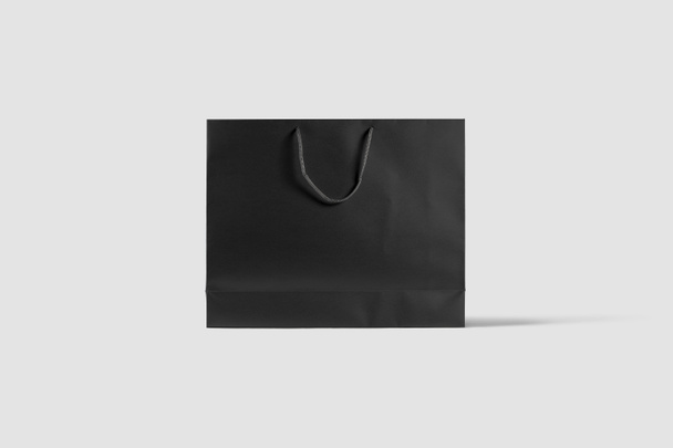 Bolsa de papel negro Mock up aislado sobre fondo gris claro. Realista photo.3D rendering
 - Foto, imagen