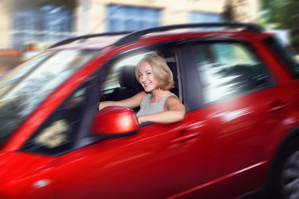 Attractive blonde young woman driving her red car and look out o - Φωτογραφία, εικόνα