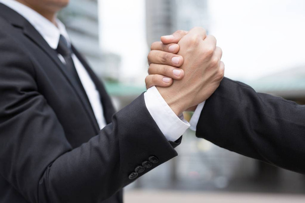 companionship hand clasping success trust, confident concept. or Closeup of a businessman hand between two colleagues on outdoor building. - Photo, Image